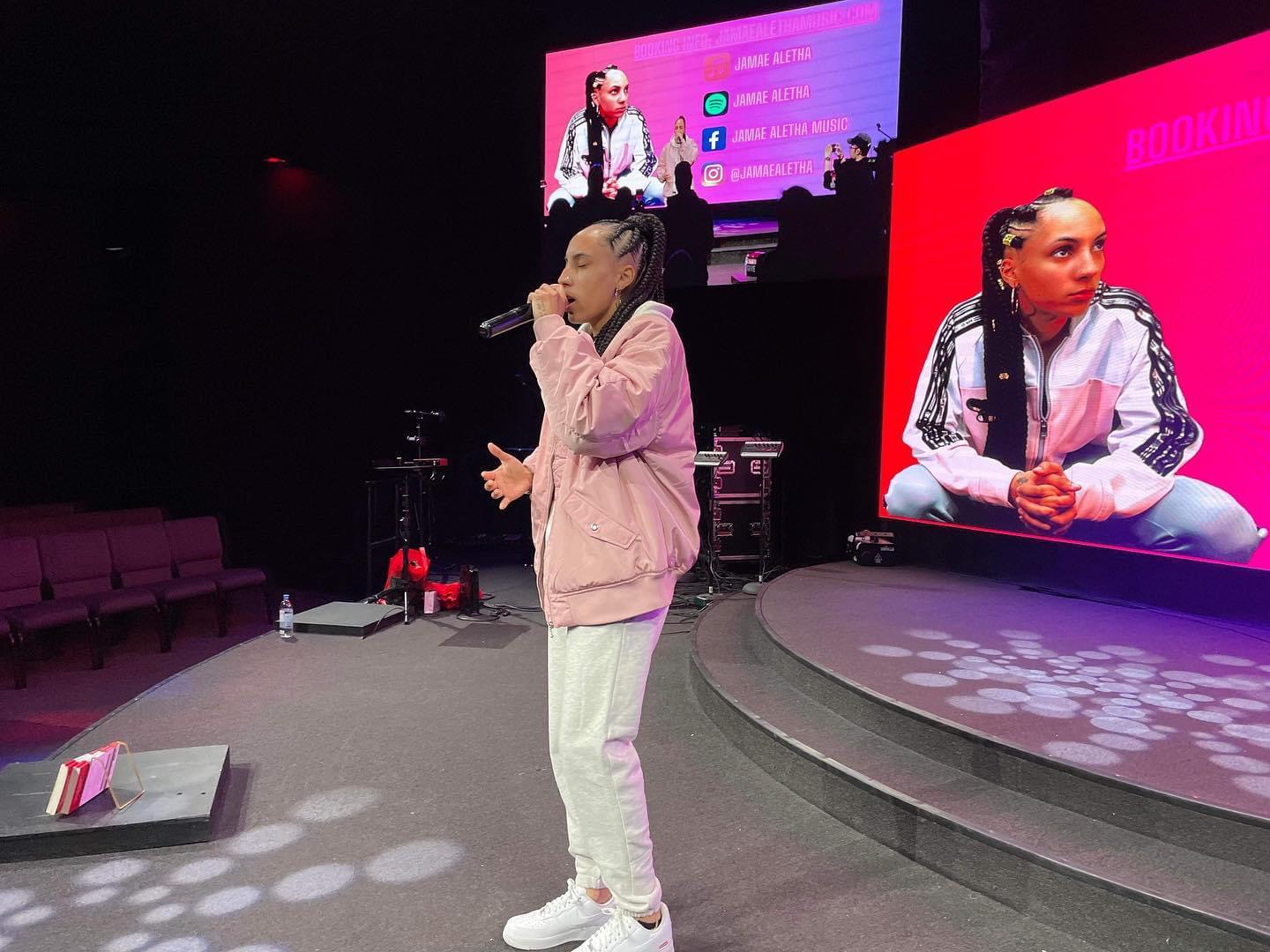 Jamae Aletha on stage in a pink jacket